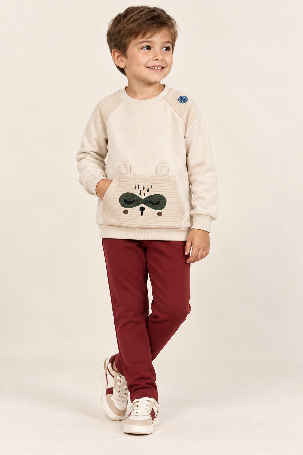 Niño con chándal crudo y granate con mapache